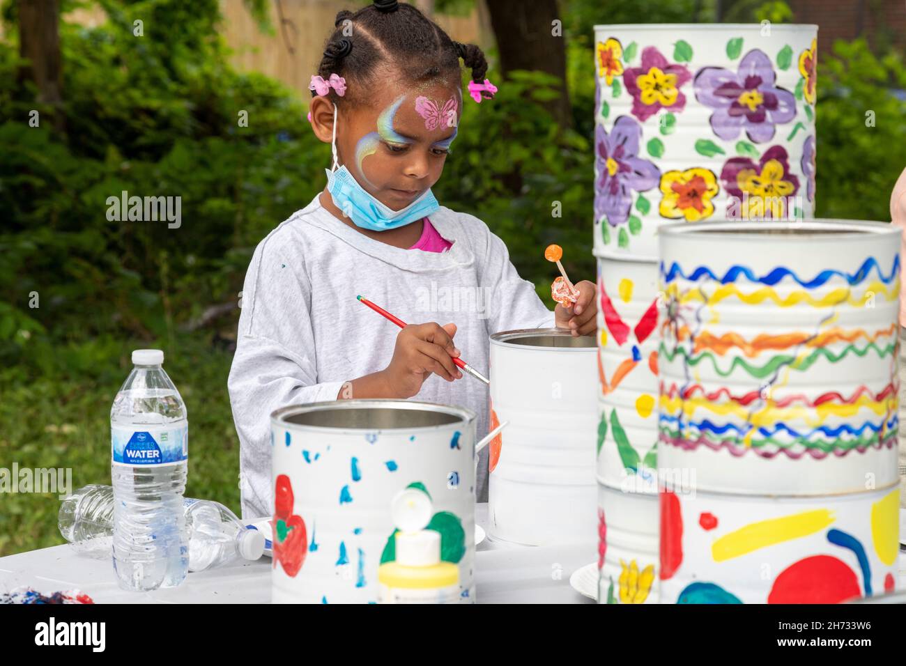 Detroit, Michigan - Ein Kind malt alte Kaffeedosen für ein Kunstprojekt in einem Kinderprogramm im Stadtteil Morningside. Die Veranstaltung war organisiert Stockfoto