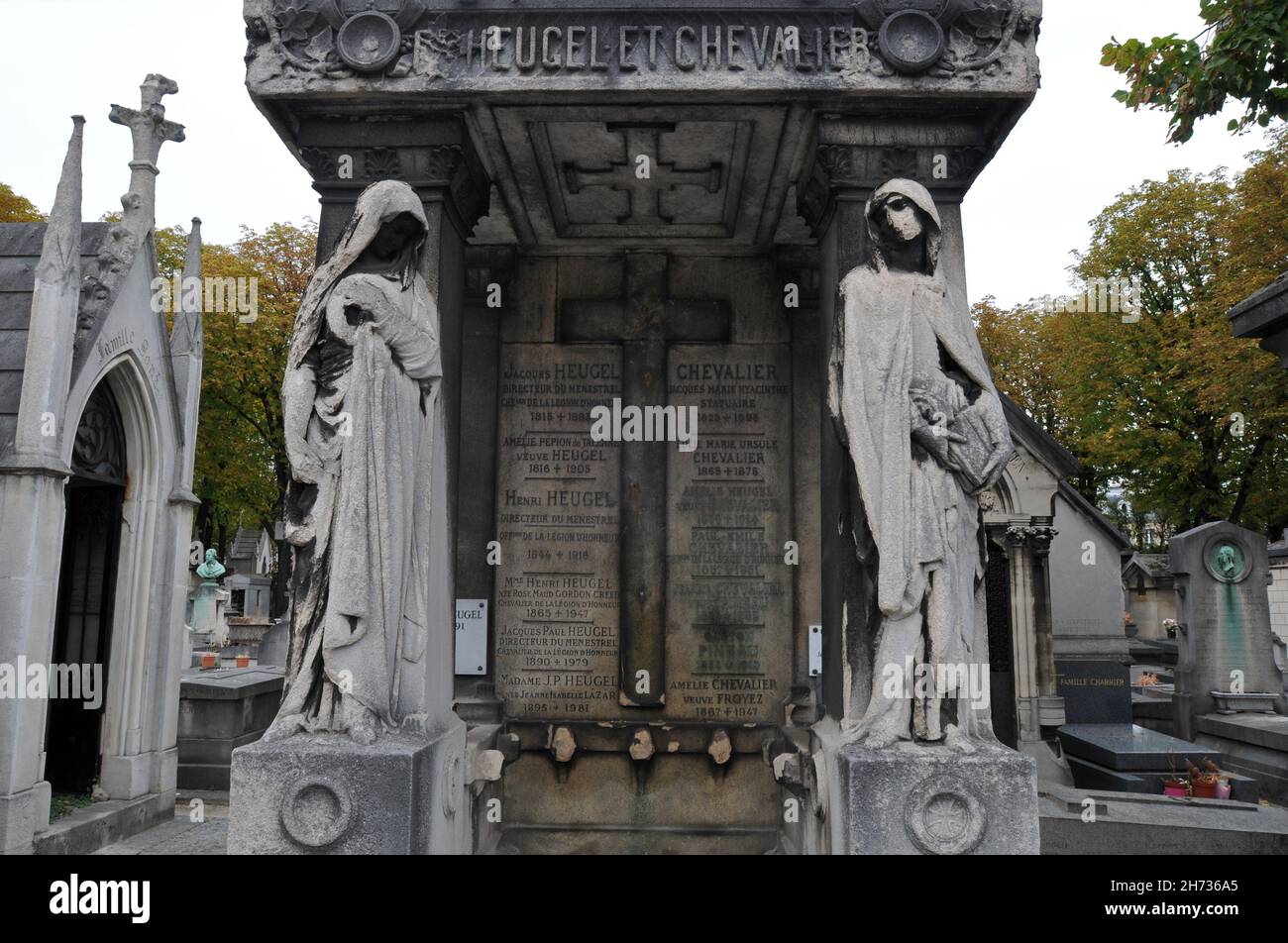 Die Statuen zweier getarnter Figuren stehen am Grab der Familie Heugel und Chevalier auf dem historischen Friedhof Passy (Cimetière de Passy) in Paris. Stockfoto