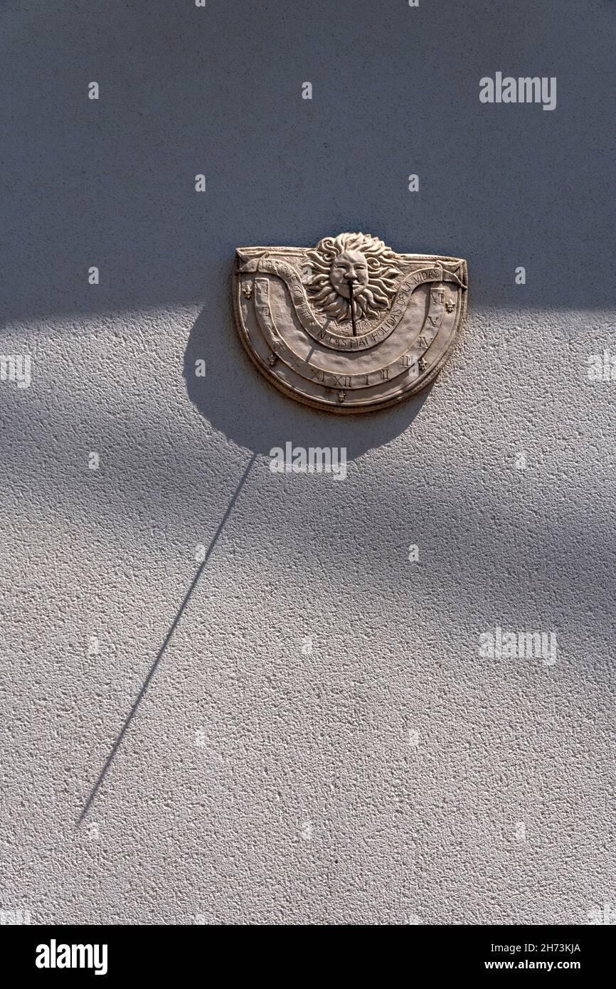 Sonnenuhr an einer Wand montiert, die während des späten Nachmittagslichts einen Schatten wirft, Frankreich Stockfoto