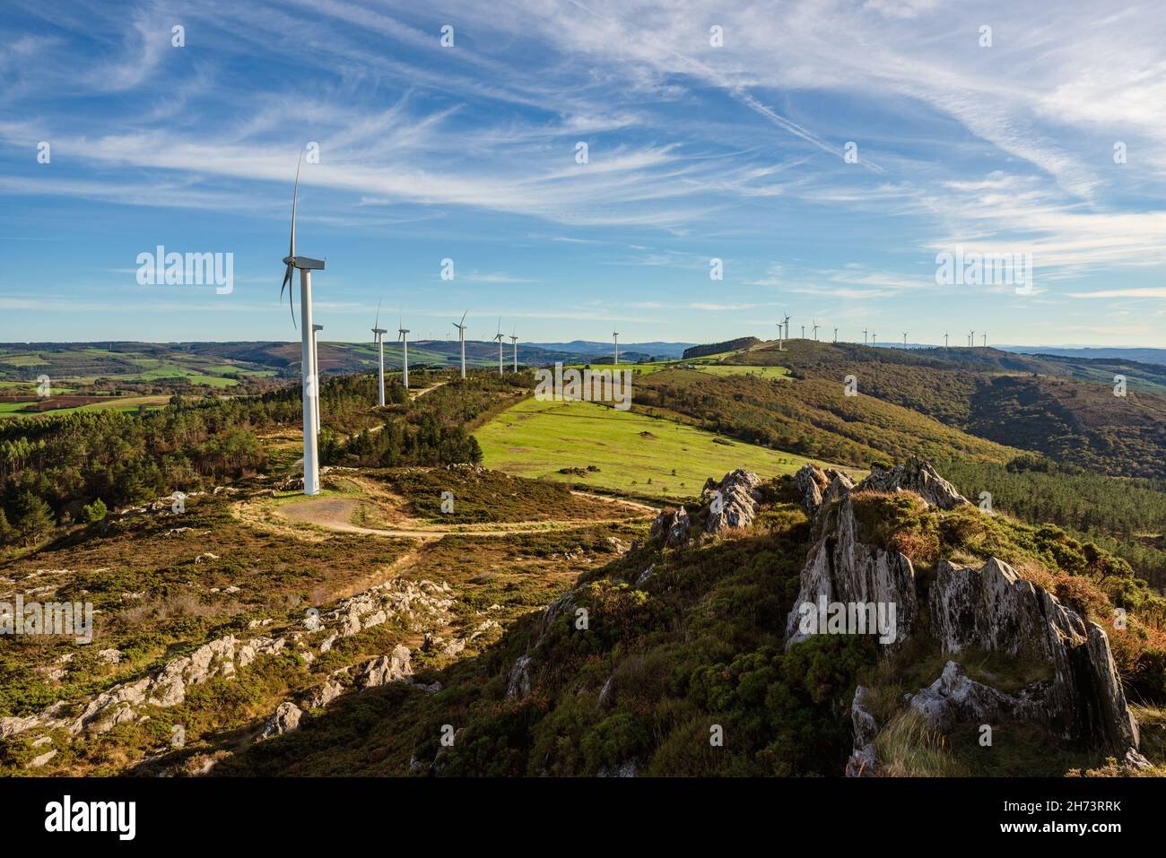 Panoramablick auf Windenergieanlagen in einer Reihe auf dem Berg. Nachhaltige Energie Stockfoto