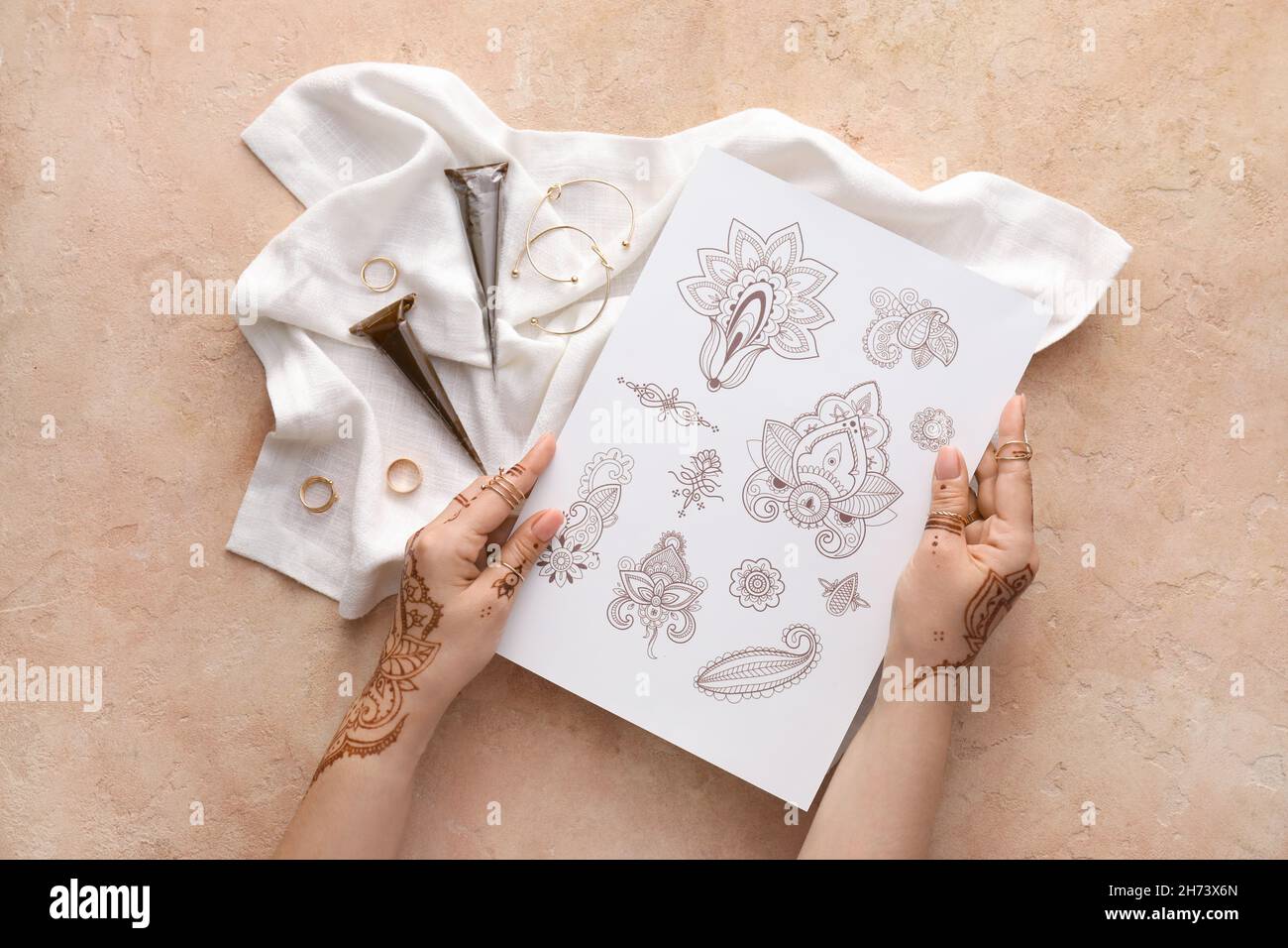 Schöne weibliche Hände mit Henna Tattoo und Ornament Beispiele auf hellem Hintergrund Stockfoto