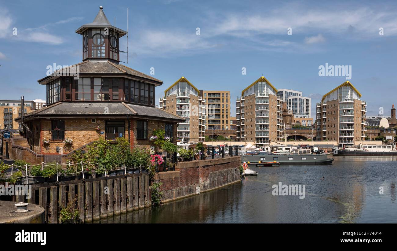 LONDON, Großbritannien - 23. JULI 2021: Blick auf das Hafenmeisterbüro in Limehouse Basin Marina mit luxuriösen Wohnblöcken im Hintergrund Stockfoto