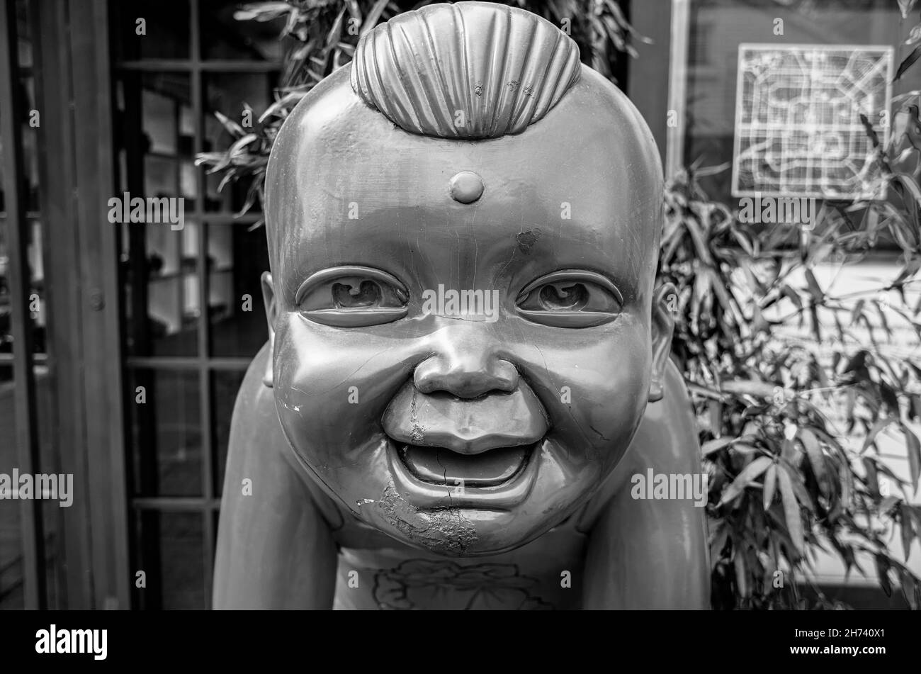 Skulptur eines lächelnden asiatischen Jungen in der Kunstzone Dashanzi 798. Chaoyang Bezirk von Peking, China. Schwarz und Weiß. Stockfoto