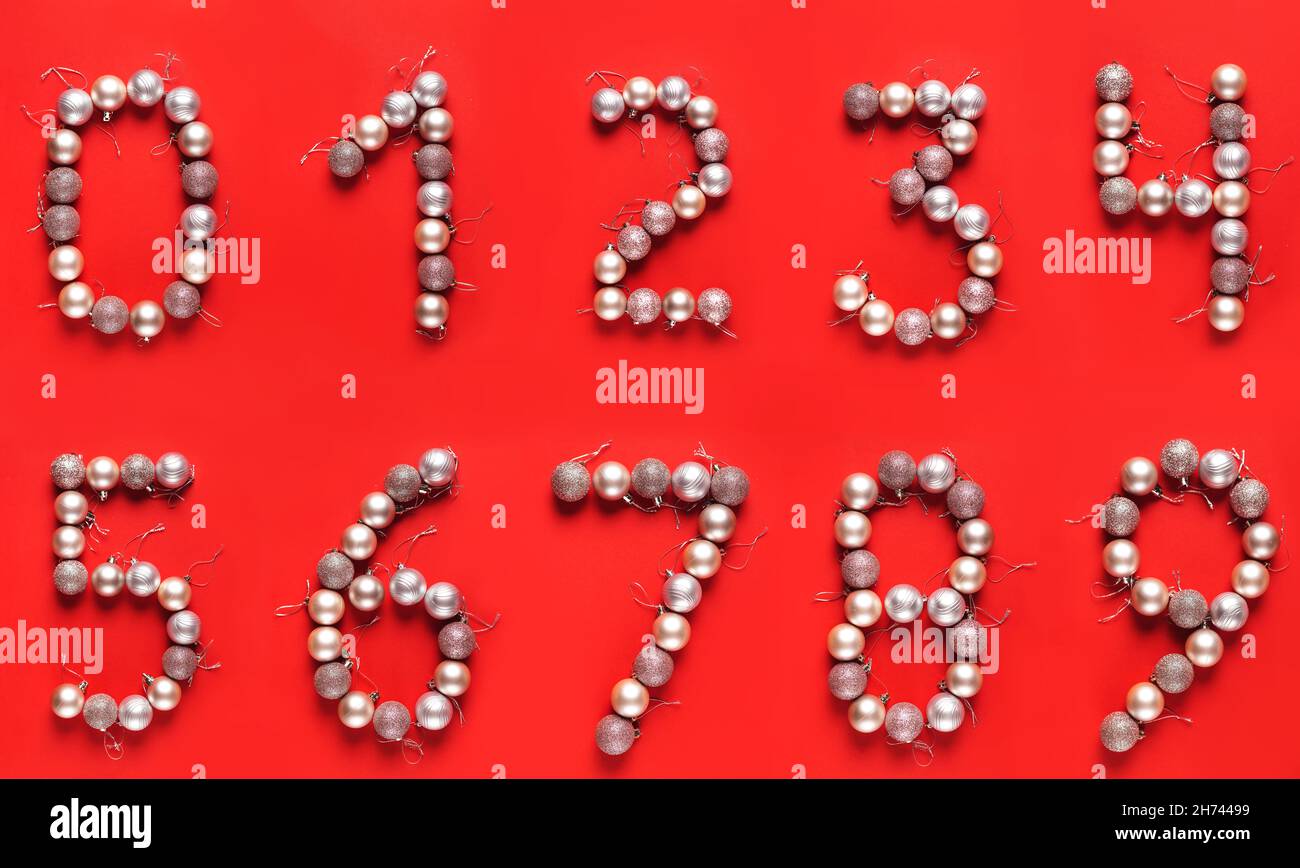 Zahlen mit Weihnachtskugeln von Null bis neun isoliert auf rotem Hintergrund ausgekleidet. Zahlen für das neue Jahr entwerfen. Flach liegend, Draufsicht, Set Stockfoto