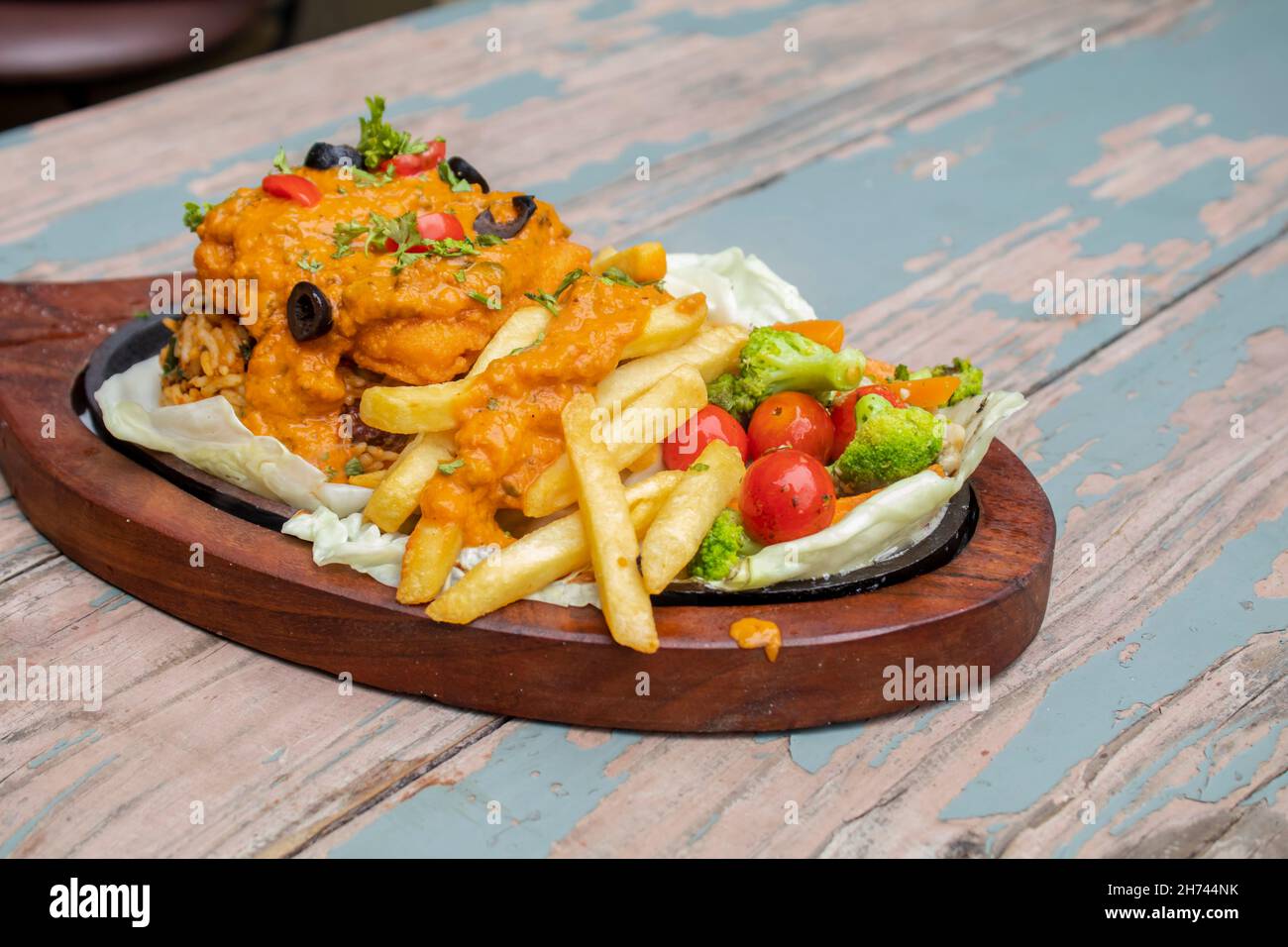 Dampfender heißer Ziszer auf Holzplatte. Ein Grillsteak-Sizzler mit warmen Platten Stockfoto