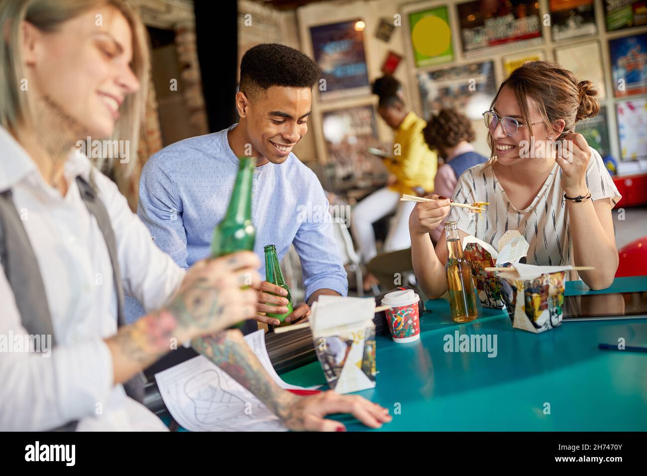 Eine Gruppe junger Kollegen, die in der Pause zusammen essen Stockfoto