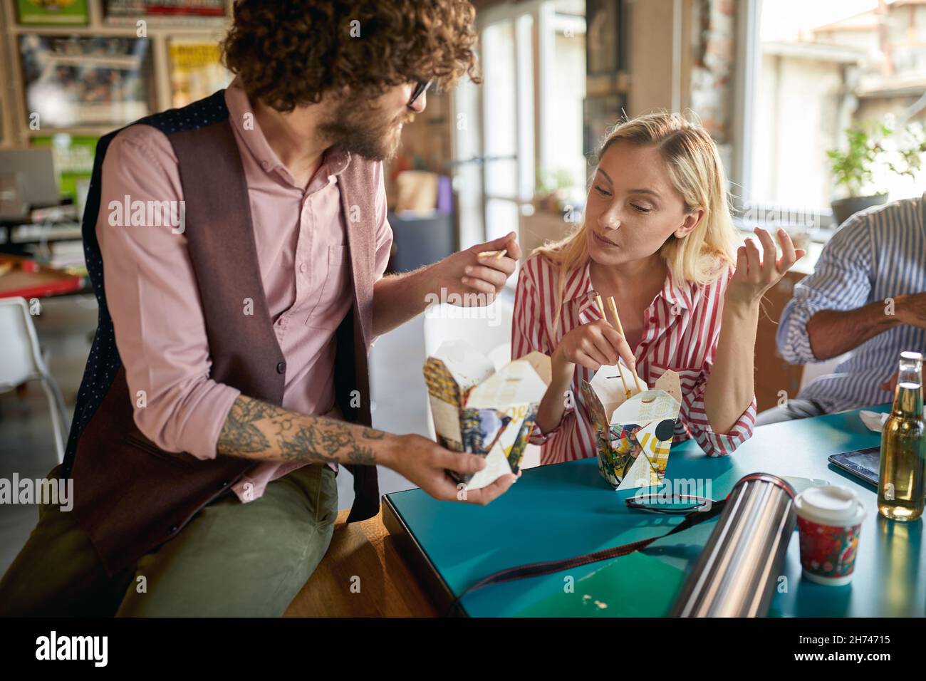 Eine Gruppe junger Kollegen, die in der Pause gemeinsam chinesisches Essen essen Stockfoto