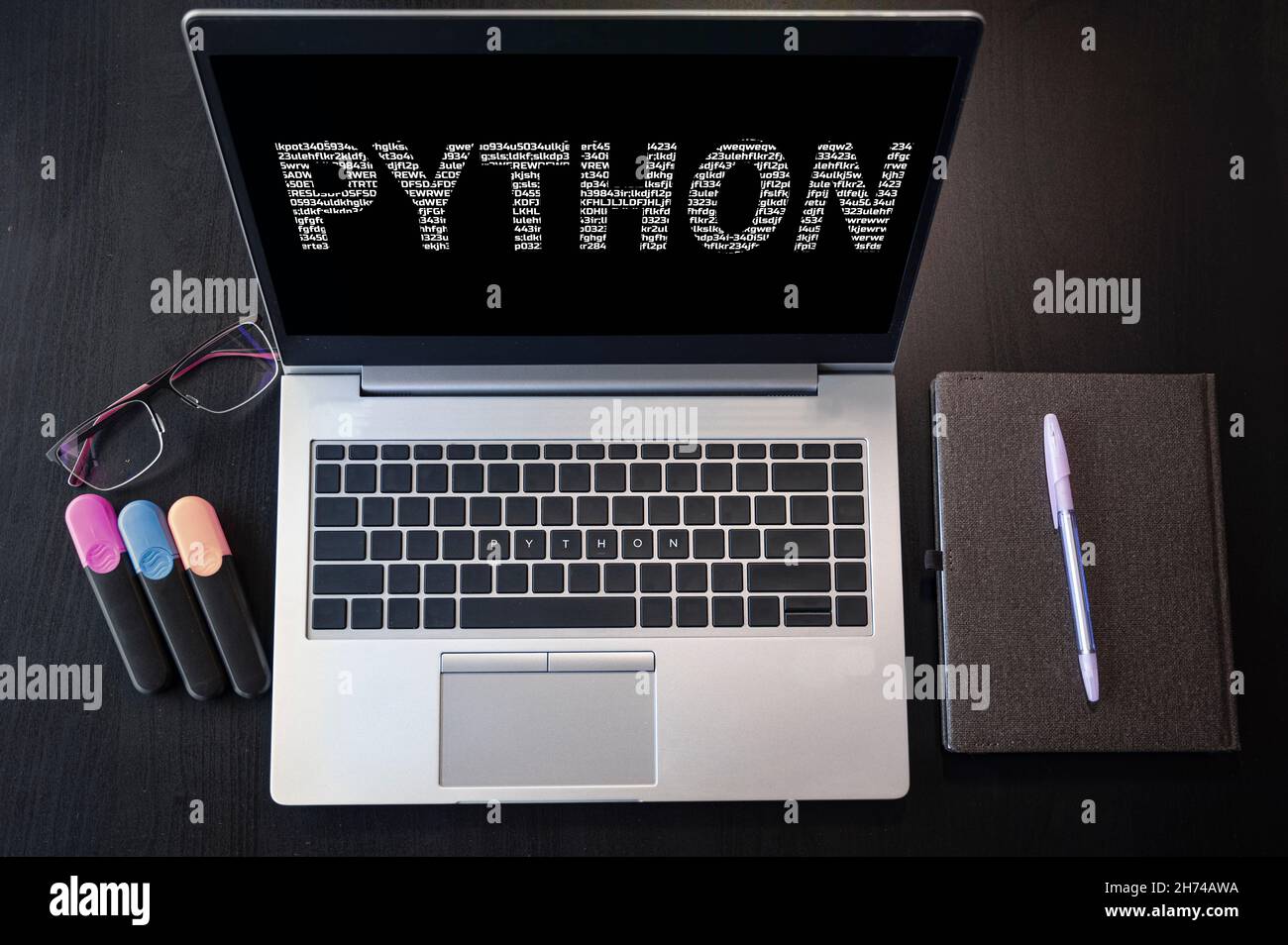 Draufsicht auf Laptop mit Text Python. Python-Beschriftung auf Laptop-Bildschirm und Tastatur. Python-Programmiersprache, Computerkurse, Schulungen lernen. Stockfoto