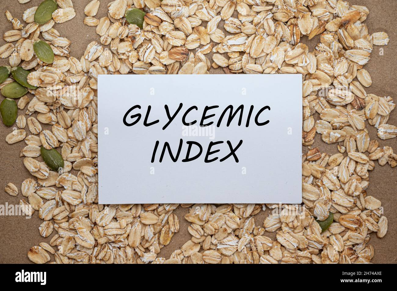 Draufsicht der Karte mit dem Text Glykämischer Index auf Hafer- und Samenhintergrund. Gesunde Ernährung Konzept. Stockfoto