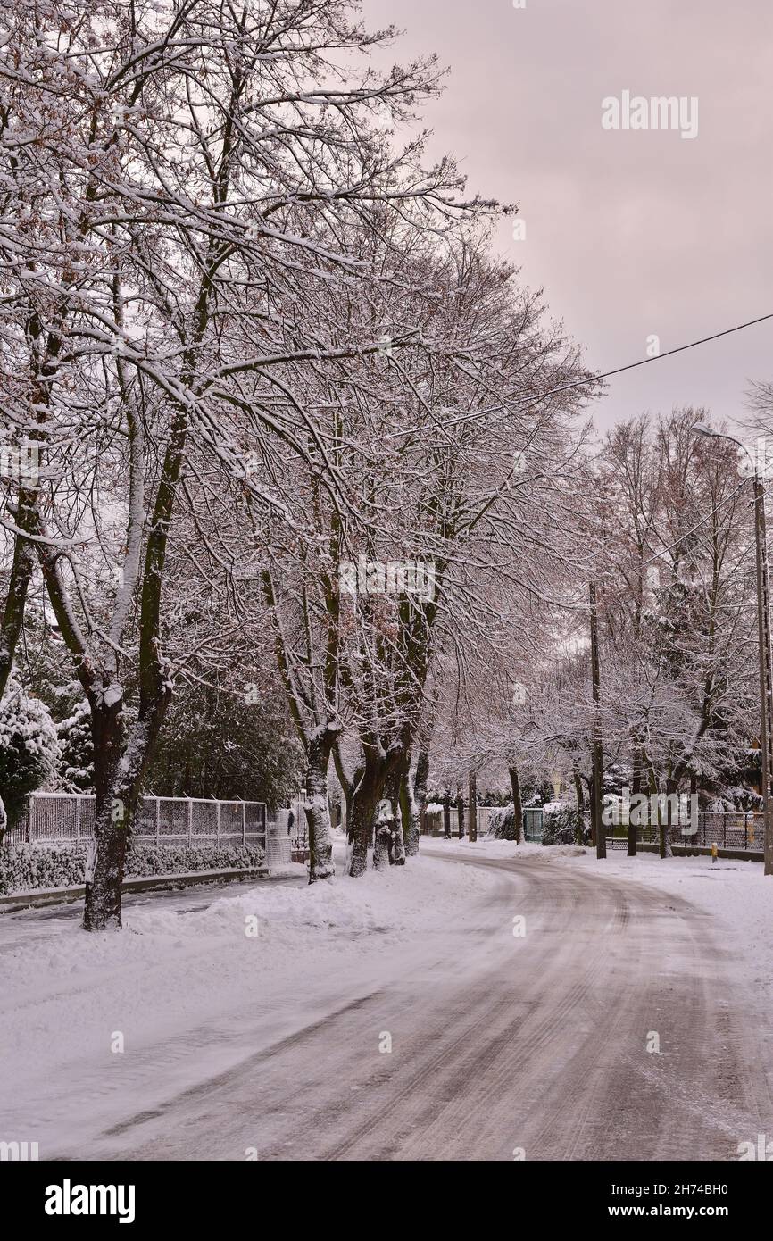 Eine von Eis und Schnee überzogene Stadtstraße an einem düsteren Wintertag. Stockfoto