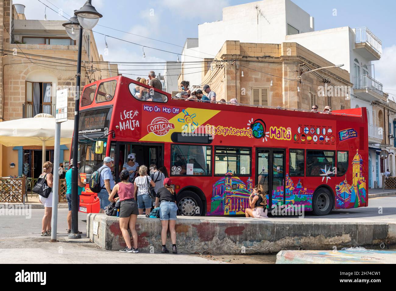 Red City Sightseeing Doppeldecker, Hop-on-Hop-off, Open-Top-Tour-Bus an einer Bushaltestelle in Marsaxlokk, Malta, Europa Stockfoto