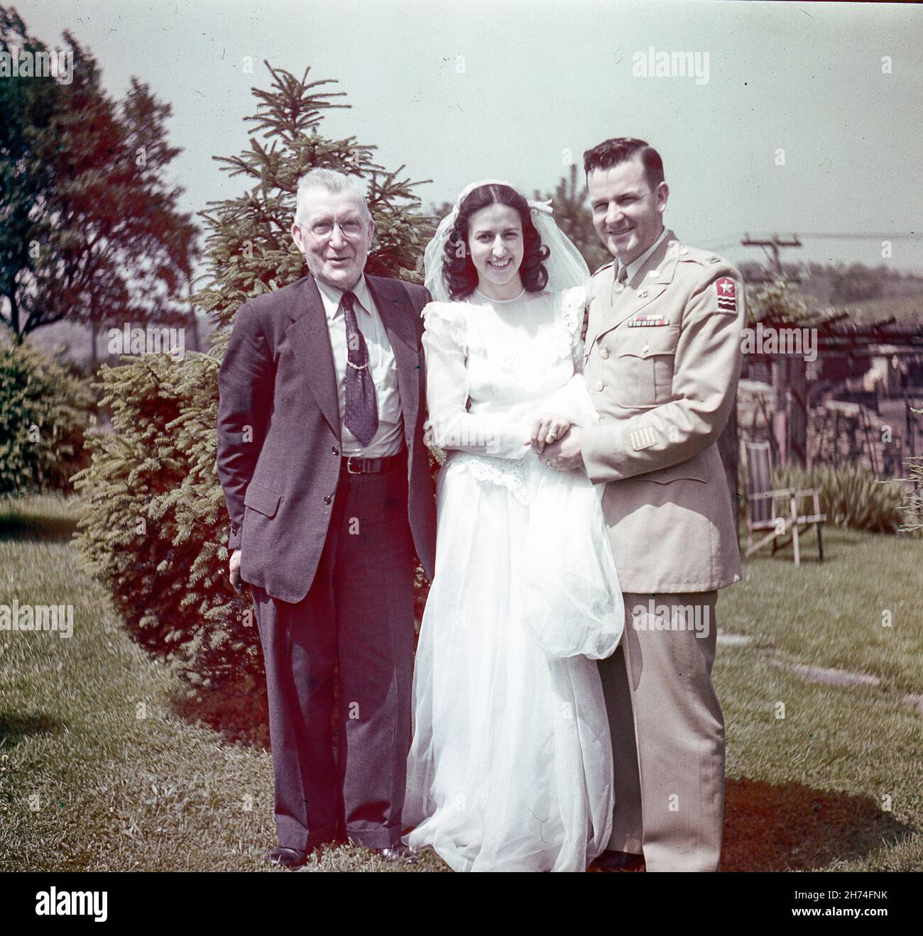 Vintage 1940s Porträt einer Braut und eines Bräutigams mit einem männlichen Verwandten einer Braut, USA Stockfoto