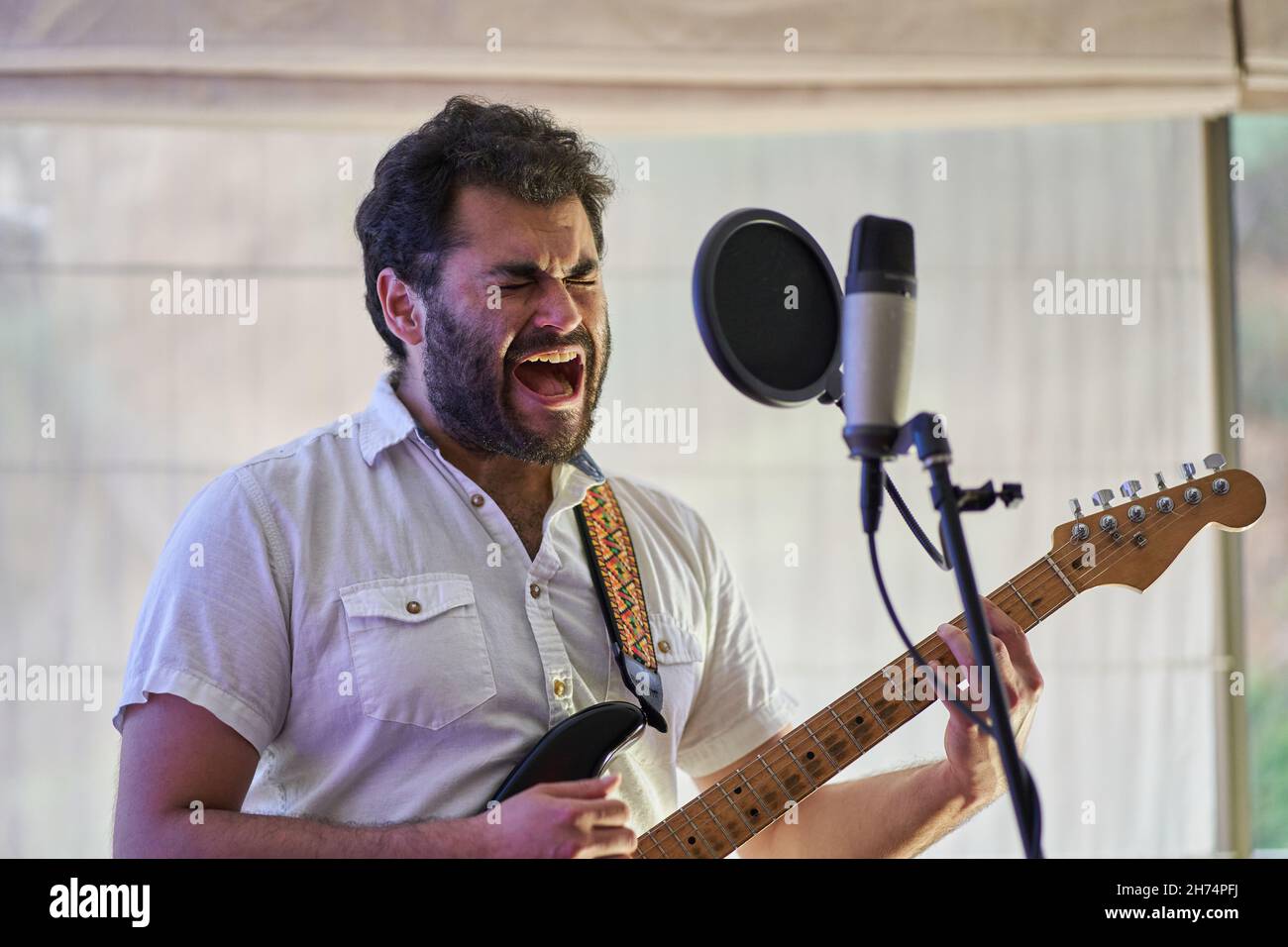 Der Musiker singt mit Wut, Leidenschaft und viel Gefühl, während er seine Gitarre spielt Stockfoto