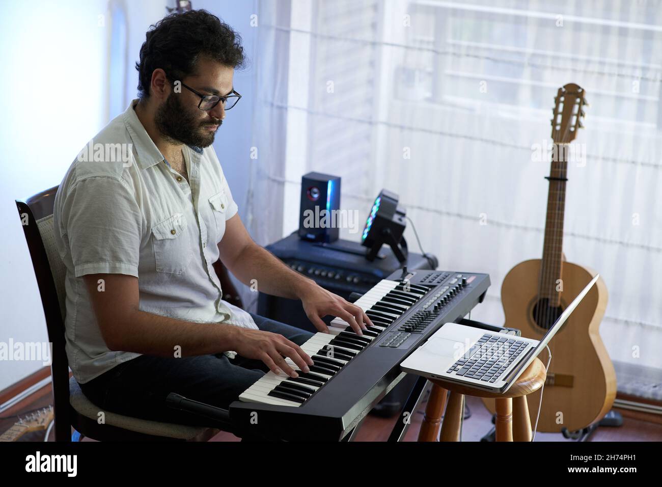 Musiker, der Klavier spielt, während er aus seinem Studio Aufnahmen Stockfoto