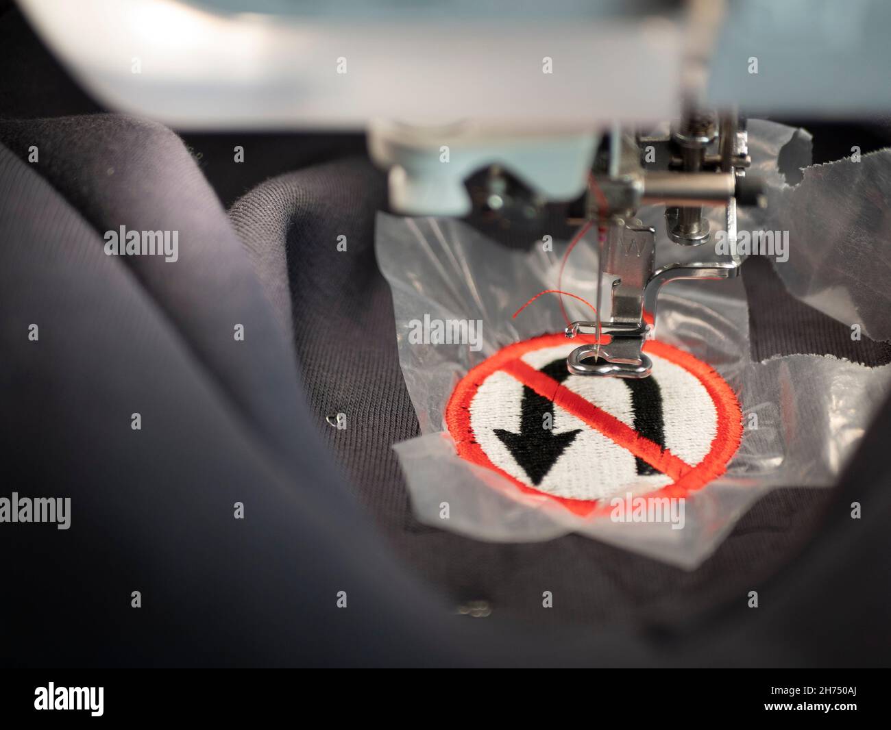 Nähmaschine und bestickt No Turning Back Verkehrsschild auf einem grauen Fleece Stoff. Textilindustrie Stockfoto