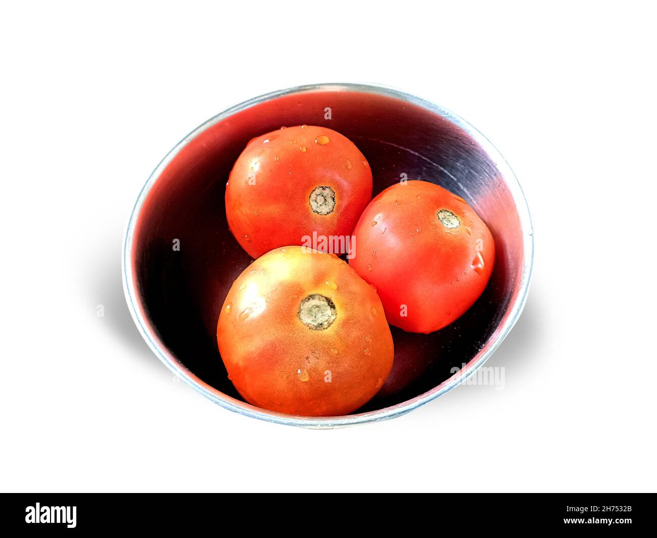 Draufsicht auf drei reife Tomaten in einer Stahlschüssel auf weißem Hintergrund Stockfoto