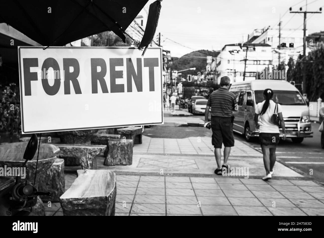 Vermieten Zeichen in der Straße, Thailand. Schwarz-Weiß-Stadtfotografie, flacher Freiheitsgrad, Fokus auf dem Schild Stockfoto