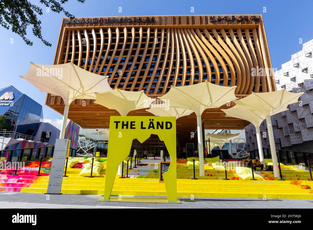 Dubai, VAE, 15.11.2021. Pavillon Baden-Württemberg auf der Expo 2020 Dubai, Holzfassade mit gelben Schirmen vorne. Stockfoto