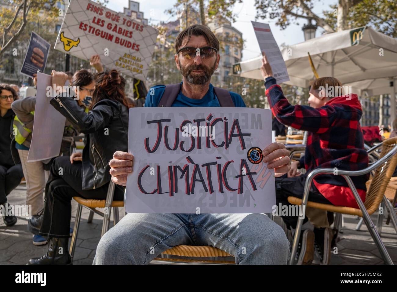 Barcelona, Spanien. 20th. November 2021. Ein Aktivist, der während der Demonstration ein Plakat mit seiner Meinung hielt.Aktivisten der Tieraufstand belegten eine Terrasse eines McDonalds-Establishments in Passeig de Gràcia in Barcelona, wo sie den Übergang zu einem gerechteren und nachhaltigeren Ernährungssystem forderten. Kredit: SOPA Images Limited/Alamy Live Nachrichten Stockfoto