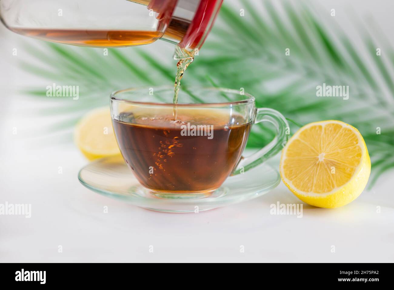Heißer schwarzer Tee in einer Tasse mit Zitrone und Ingwer trinken Stockfoto