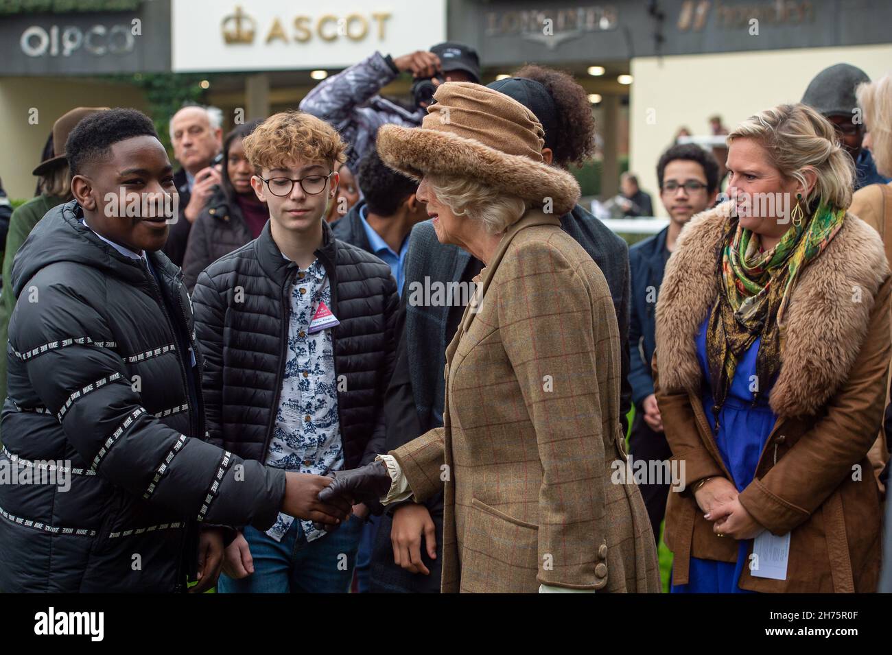 Ascot, Bergen, Großbritannien. 20th. November 2021. Camilla, Herzogin von Cornwall und Präsidentin des Ebony Horse Clubs in Brixton, unterhielt sich mit Jugendlichen des Ebony Horse Clubs, der jungen Menschen hilft, Reiten zu lernen und ihnen Selbstvertrauen zu geben. Nachdem der „Limited Handicap Steeple“ des Ebony Horse Clubs von Jockey Bryony Frost auf Pferd Jeremy Pass gewonnen wurde, hielt die Herzogin die Präsentation vor dem Bräutigam des Pferdes, einem Vertreter von Trainer Paul Nicholls und dem siegreichen Jockey Bryony Frost in Begleitung von Mitgliedern des Ebony Horse Clubs. Quelle: Maureen McLean/Alamy Live News Stockfoto