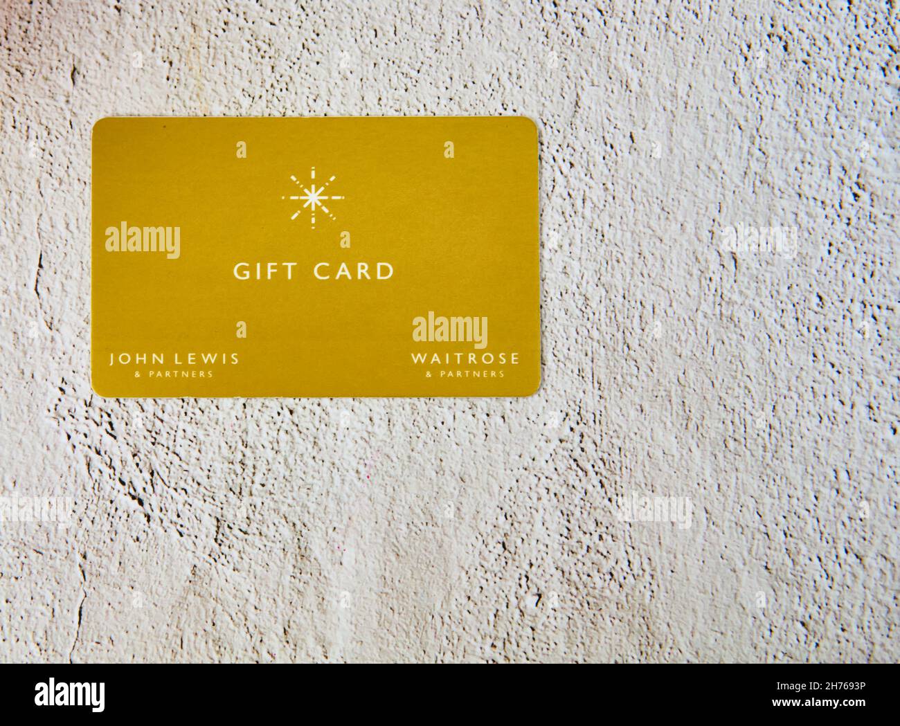 Gelbe Geschenkkarte von John Lewis und Waitrose auf grauem Hintergrund. Stockfoto