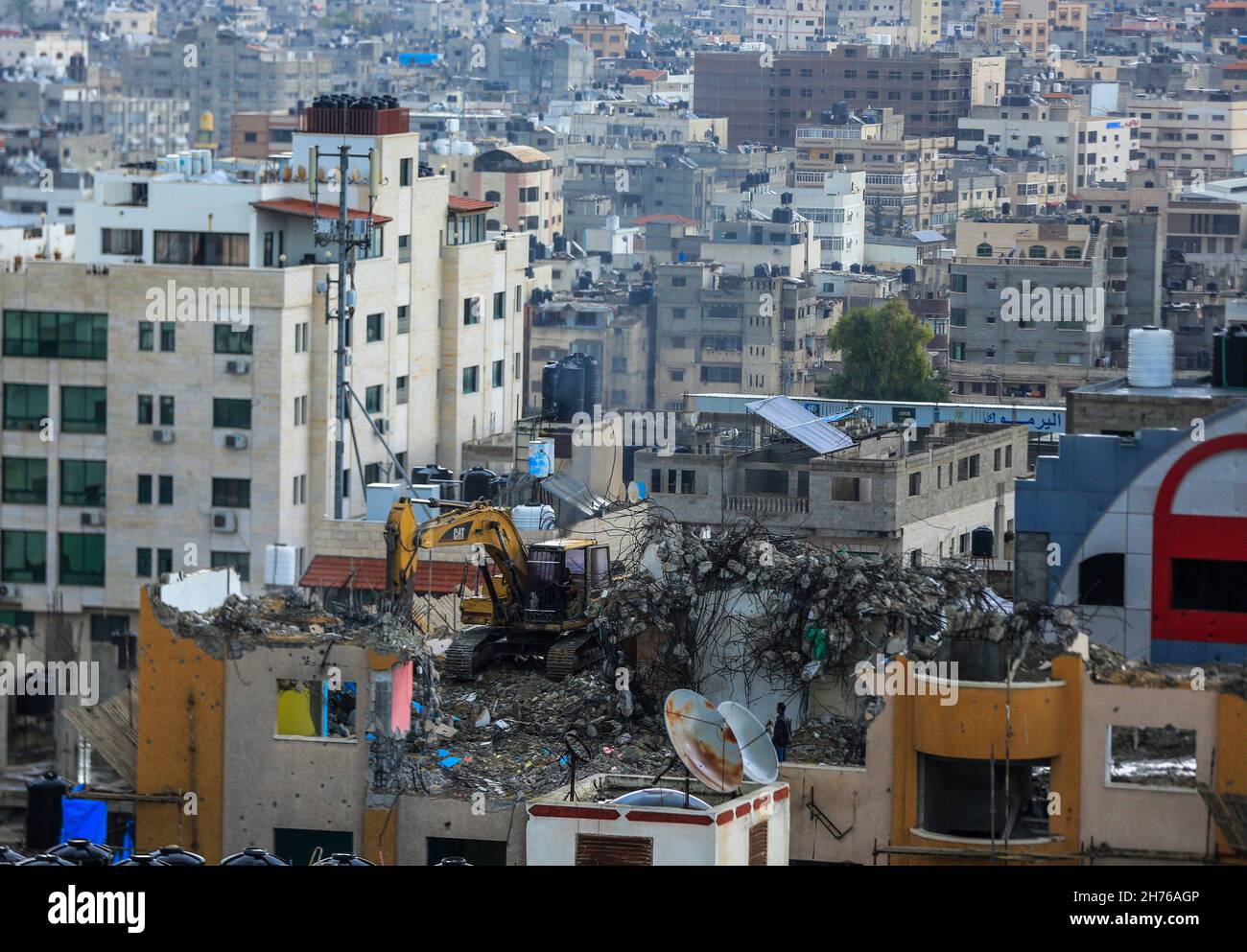 Gaza, Palästina. 20th. November 2021. Palästinensische Arbeiter entfernen die Trümmer des Al-Jawhara Turms im Viertel Al-Rimal in Gaza-Stadt, der im Mai 2021 von israelischen Luftangriffen angegriffen wurde. Kredit: SOPA Images Limited/Alamy Live Nachrichten Stockfoto