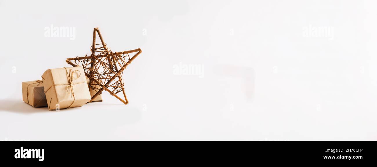 Handgemachte Sterne, Geschenke in einfachen Papier Verpackung hellen Hintergrund. Festliche Komposition zu Weihnachten oder Neujahr Stockfoto