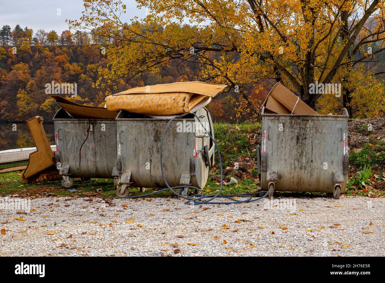 Öffnen Sie Metallabfallbehälter mit gebrauchten Möbeln und anderen Haushaltsgegenständen, die weggeworfen werden Stockfoto