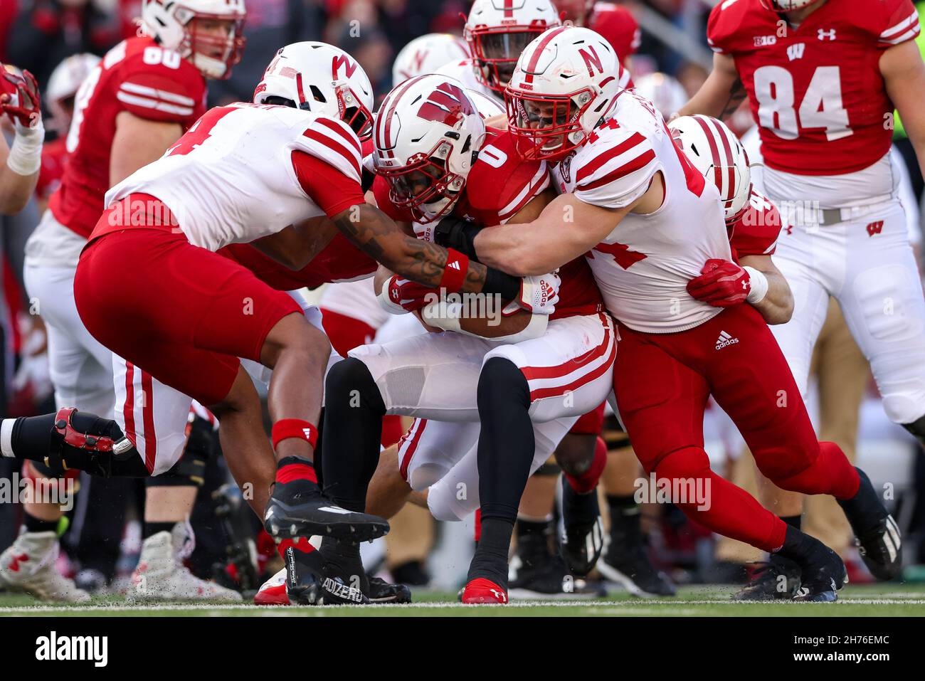 Madison, WI, USA. 20th. November 2021. Wisconsin Dachse, die zurücklaufen Braelon Allen (0) wird von Nebraska Cornhuskers Linebacker Garrett Nelson (44) und Sicherheit Myles Farmer (4) während des NCAA Football Spiels zwischen den Nebraska Cornhuskers und den Wisconsin Dachsen im Camp Randall Stadium in Madison, WI, angegangen. Darren Lee/CSM/Alamy Live News Stockfoto