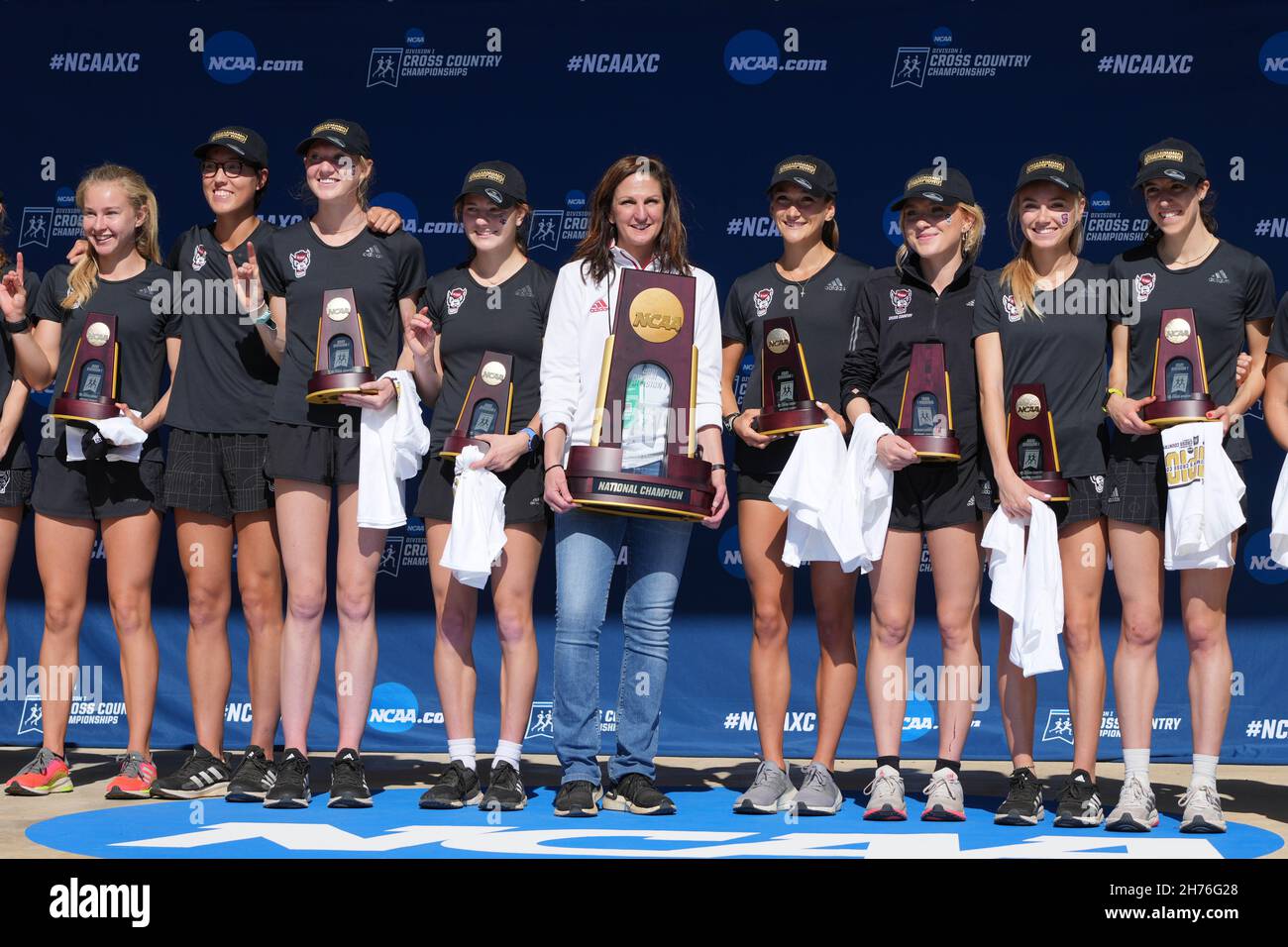 Mitglieder der NC Carolina State Wolfpack Damen-Mannschaft und Trainerin Laurie Henes posieren mit Mannschaftstitel Torphy während der NCAA Cross Country Meisterschaften Stockfoto