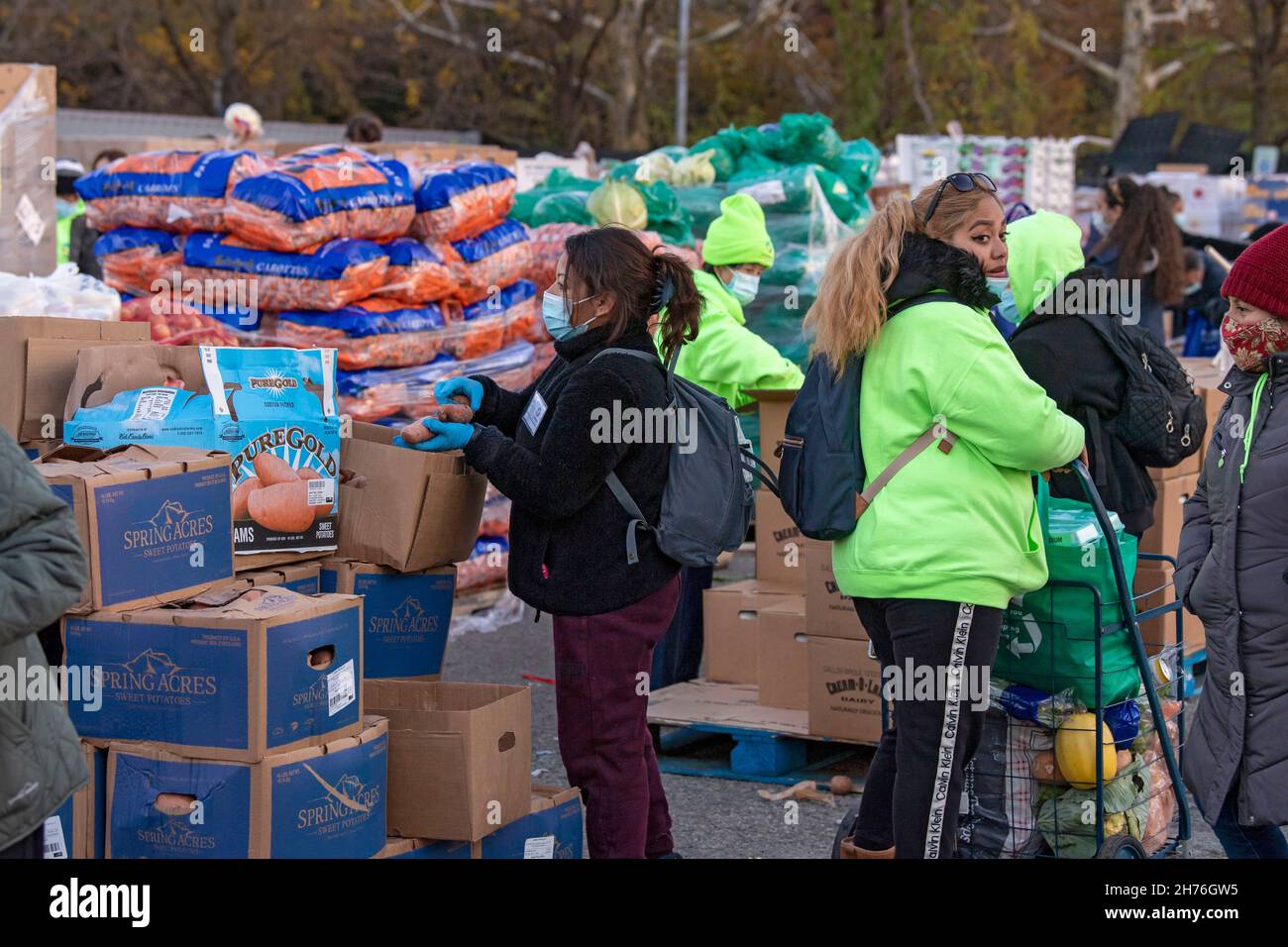 NEW YORK, NY – 20. NOVEMBER: Bei einer Imbiß-Bank erhalten die Menschen am 20. November 2021 in Queens Borough in New York City ein kostenloses Essen. Die Gouverneurin Kathy Hochul unterzeichnet ein Gesetz, in dem das Nourish New York-Programm dauerhaft im Staatsrecht verankert ist. Die Unterzeichnung dieses Gesetzes erfolgt kurz vor dem Erntedankfest und bekräftigt die Verpflichtung von New York, Menschen mit Ernährungsunsicherheit im ganzen Staat zu unterstützen. Stockfoto