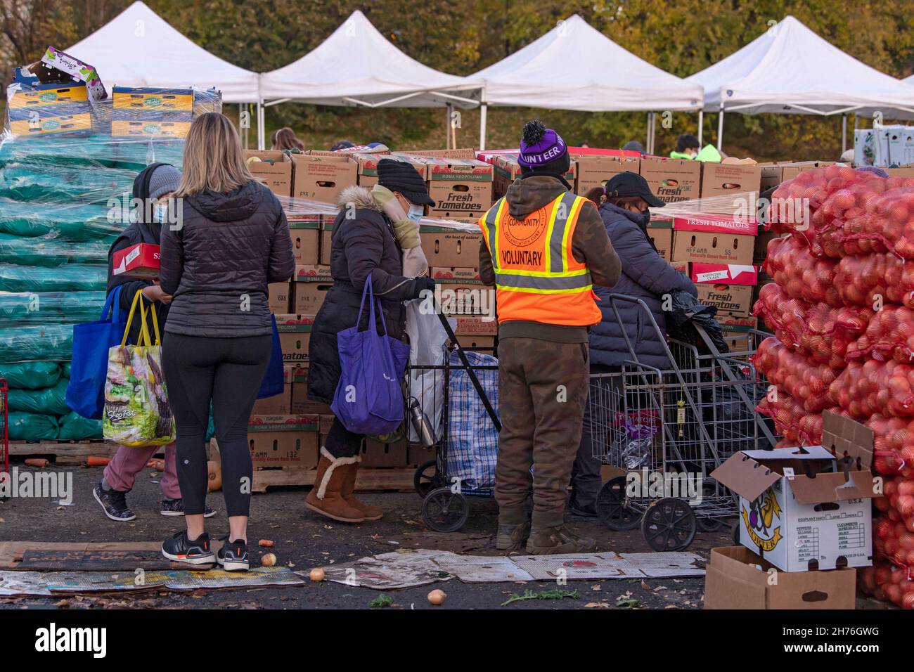 NEW YORK, NY – 20. NOVEMBER: Bei einer Imbiß-Bank erhalten die Menschen am 20. November 2021 in Queens Borough in New York City ein kostenloses Essen. Die Gouverneurin Kathy Hochul unterzeichnet ein Gesetz, in dem das Nourish New York-Programm dauerhaft im Staatsrecht verankert ist. Die Unterzeichnung dieses Gesetzes erfolgt kurz vor dem Erntedankfest und bekräftigt die Verpflichtung von New York, Menschen mit Ernährungsunsicherheit im ganzen Staat zu unterstützen. Stockfoto