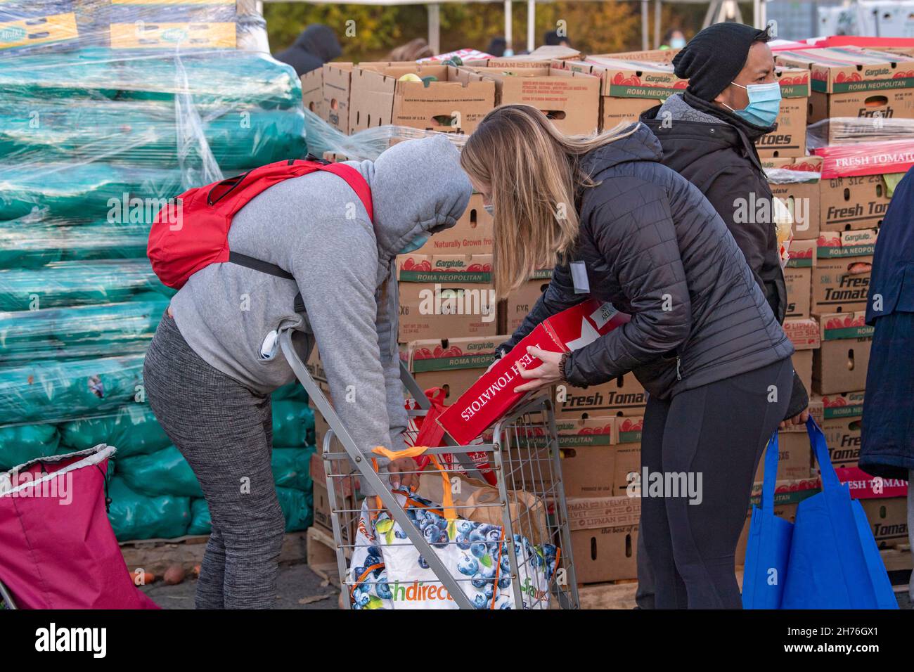 NEW YORK, NY – 20. NOVEMBER: Bei einer Imbiß-Bank erhalten die Menschen am 20. November 2021 in Queens Borough in New York City ein kostenloses Essen. Die Gouverneurin Kathy Hochul unterzeichnet ein Gesetz, in dem das Nourish New York-Programm dauerhaft im Staatsrecht verankert ist. Die Unterzeichnung dieses Gesetzes erfolgt kurz vor dem Erntedankfest und bekräftigt die Verpflichtung von New York, Menschen mit Ernährungsunsicherheit im ganzen Staat zu unterstützen. Stockfoto