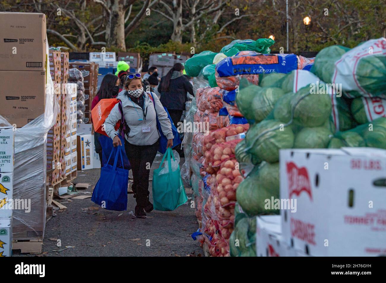 NEW YORK, NY – 20. NOVEMBER: Bei einer Imbiß-Bank erhalten die Menschen am 20. November 2021 in Queens Borough in New York City ein kostenloses Essen. Die Gouverneurin Kathy Hochul unterzeichnet ein Gesetz, in dem das Nourish New York-Programm dauerhaft im Staatsrecht verankert ist. Die Unterzeichnung dieses Gesetzes erfolgt kurz vor dem Erntedankfest und bekräftigt die Verpflichtung von New York, Menschen mit Ernährungsunsicherheit im ganzen Staat zu unterstützen. Stockfoto