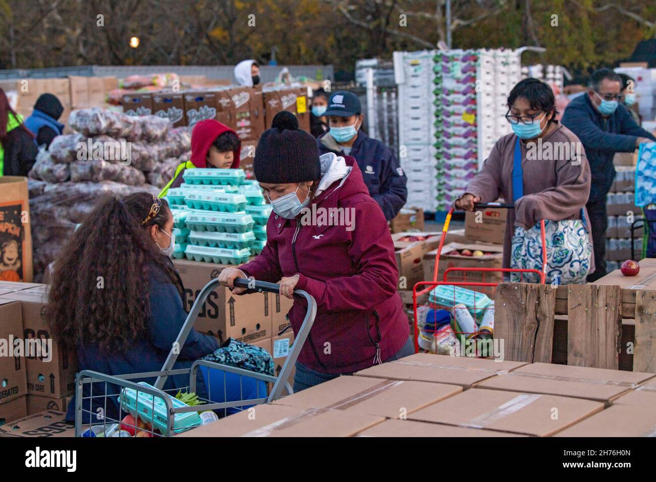 NEW YORK, NY – 20. NOVEMBER: Bei einer Imbiß-Bank erhalten die Menschen am 20. November 2021 in Queens Borough in New York City ein kostenloses Essen. Die Gouverneurin Kathy Hochul unterzeichnet ein Gesetz, in dem das Nourish New York-Programm dauerhaft im Staatsrecht verankert ist. Die Unterzeichnung dieses Gesetzes erfolgt kurz vor dem Erntedankfest und bekräftigt die Verpflichtung von New York, Menschen mit Ernährungsunsicherheit im ganzen Staat zu unterstützen. Stockfoto