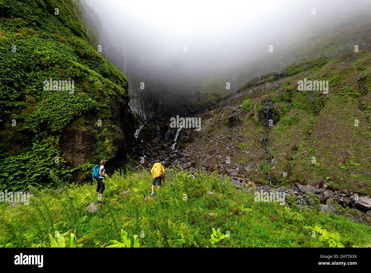 Mutter und Sohn wandern zum Wasserfall Ribeira grande. Flores, Azoren, Portugal Stockfoto