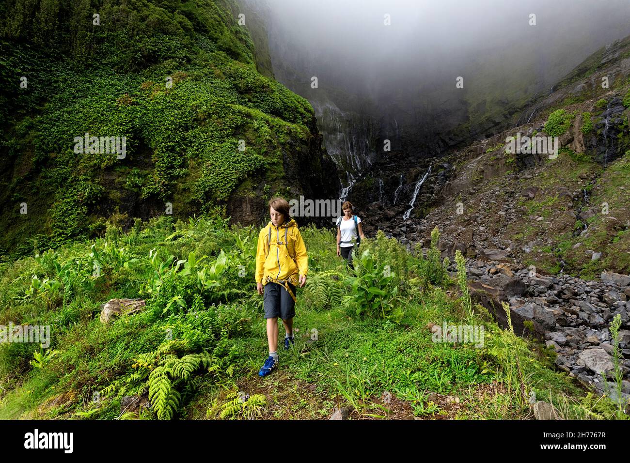 Mutter und Sohn wandern zum Wasserfall Ribeira grande. Flores, Azoren, Portugal Stockfoto