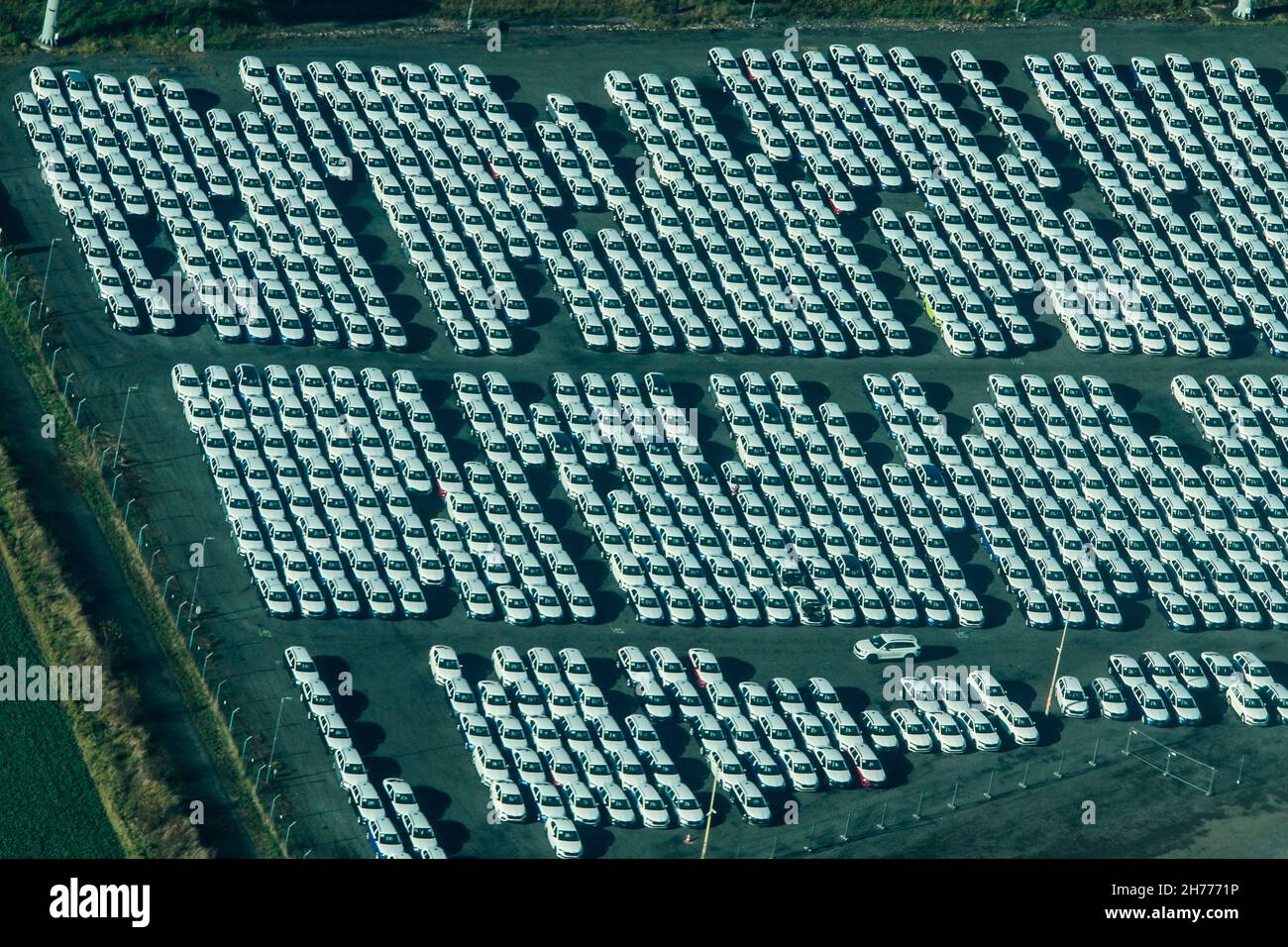 Die Luftaufnahme der geparkten Neuwagen, die auf fehlende Komponenten (elektronische Chips) warten. Kann nicht an die Kunden verkauft werden. Stockfoto