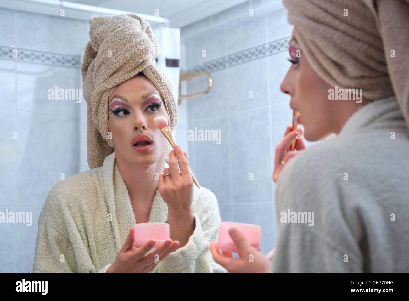 Ziehen Sie Queen Person Anwendung der Rouge auf die Wangen nach dem Duschen. Stockfoto