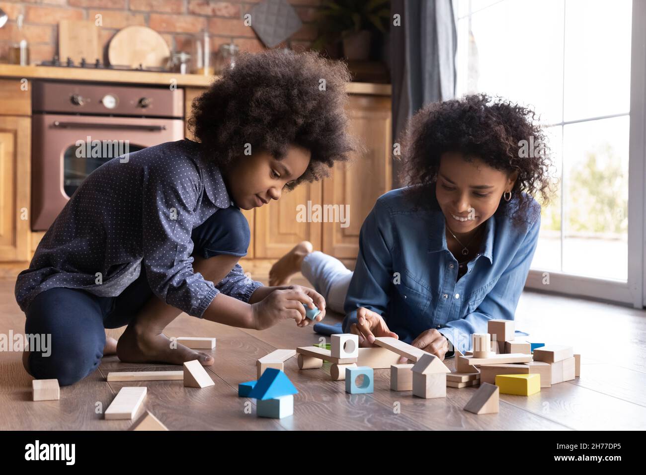 Glücklich niedlich kleine afroamerikanische Kind spielt Spielzeug mit Mama. Stockfoto