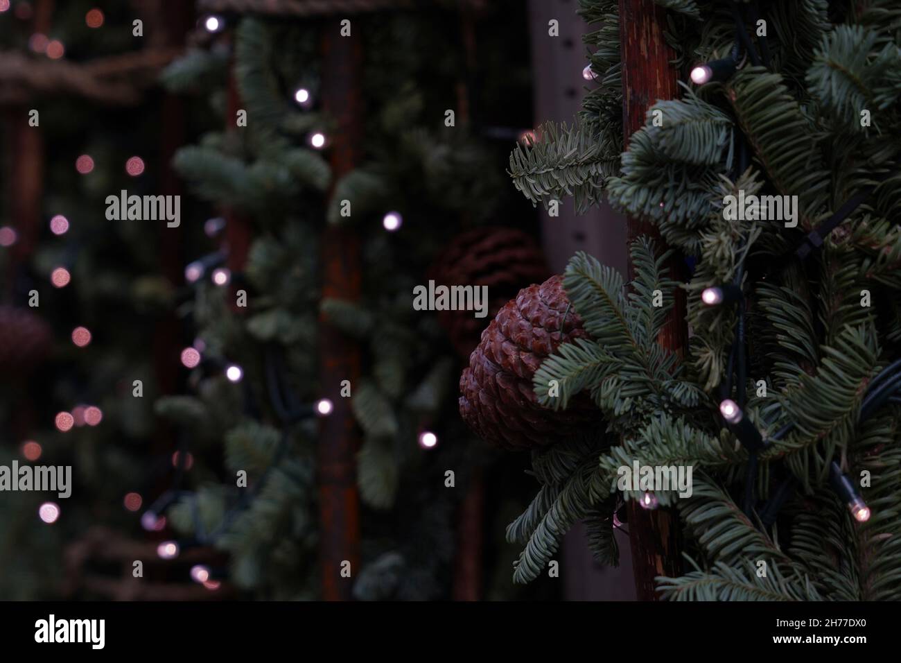 Weihnachtsdekoration aus Nadelbäumen mit Zinnen und winzigen Lichtern, die an den Zweigen befestigt sind. Stockfoto