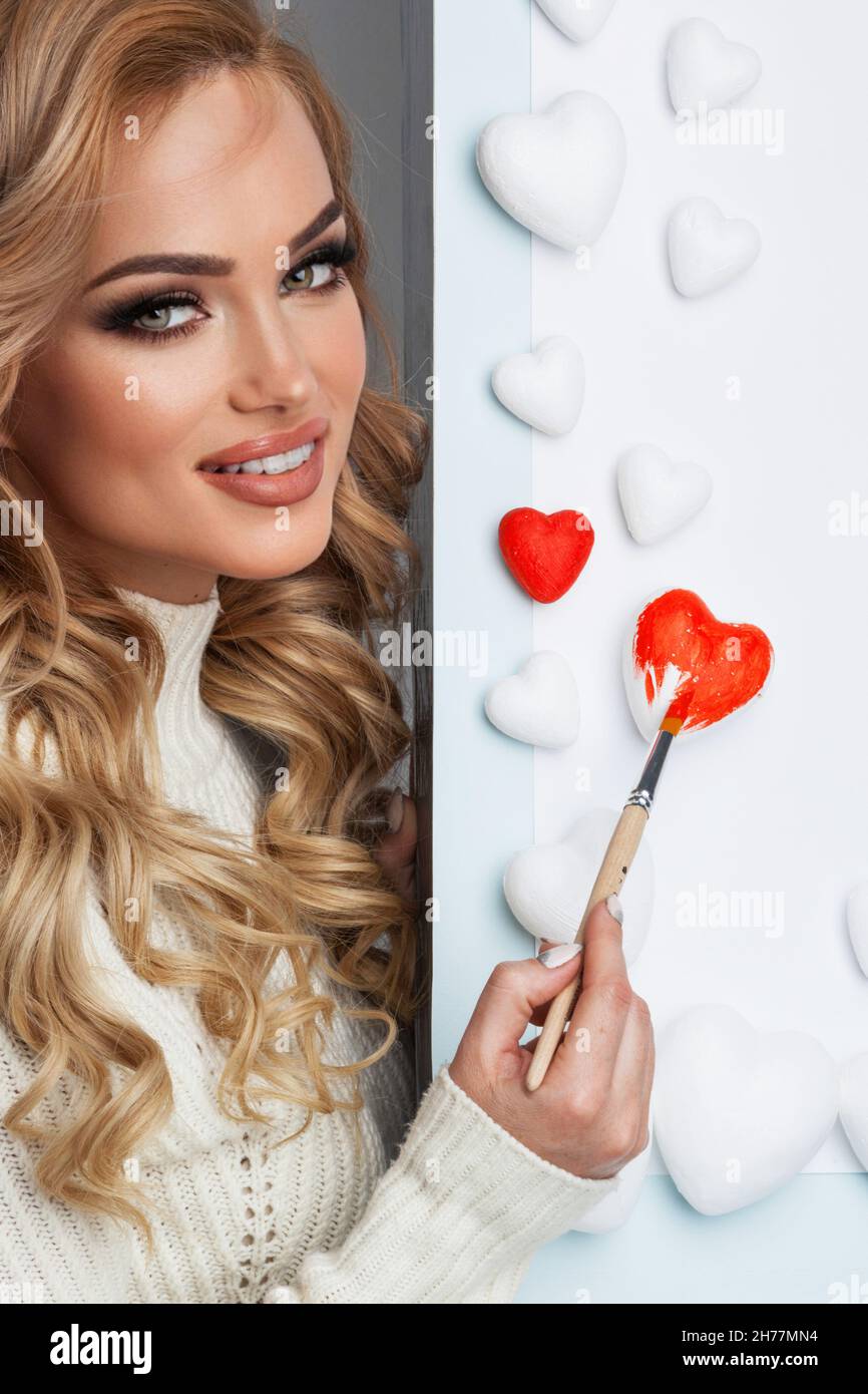 Schöne junge Frau Malerei Herzen mit roter Farbe Valentinstag Liebe Konzept Stockfoto
