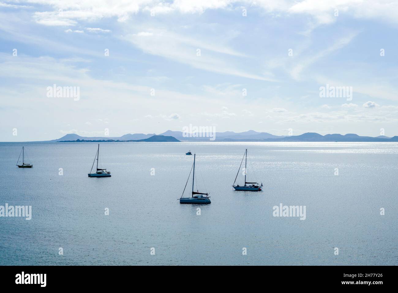 Segelyachten ankerten am Papagayo Beach Lanzarote. Fuerteventura ist im Hintergrund zu sehen. Stockfoto
