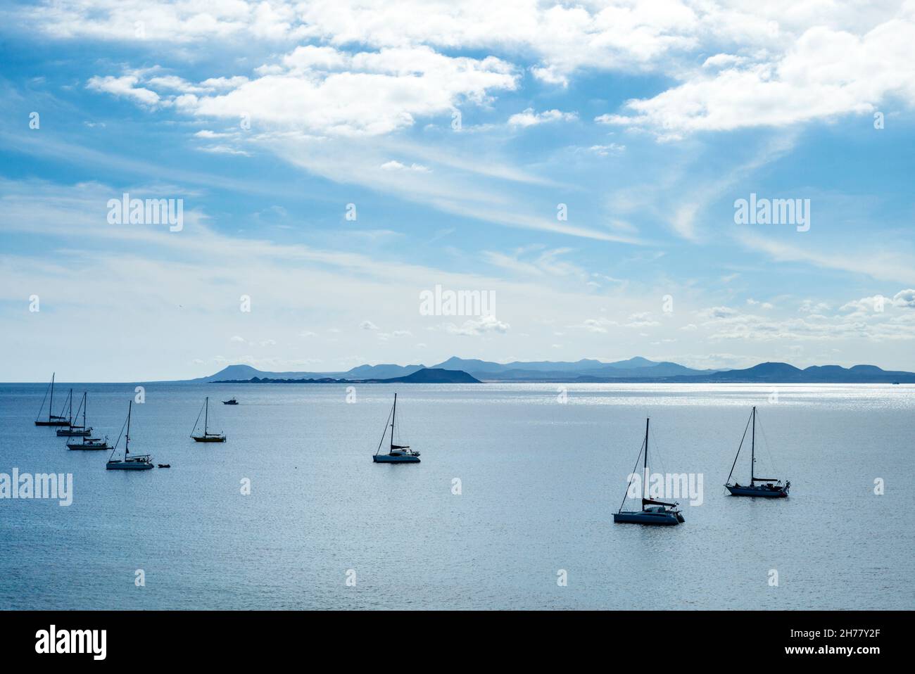 Segelyachten ankerten am Papagayo Beach Lanzarote. Fuerteventura ist im Hintergrund zu sehen. Stockfoto