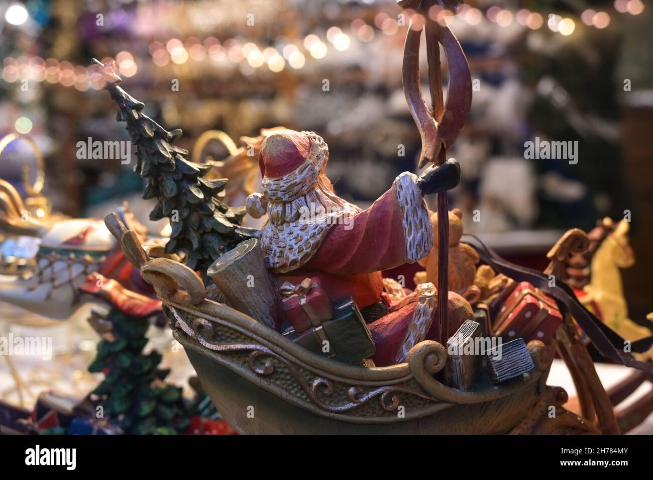 Lübeck, 19. November 2021: Geschnitzter Weihnachtsmann aus Holz auf seinem Schlitten von hinten als Dekoration auf dem Weihnachtsmarkt, ausgewählter Fokus, Narro Stockfoto