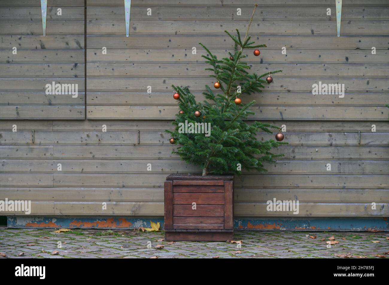 Schräge Tanne mit verbliebener Dekoration steht vor einem geschlossenen Stand auf dem Weihnachtsmarkt verlassen, abgesagt Veranstaltung wegen Coronavirus Pfanne Stockfoto