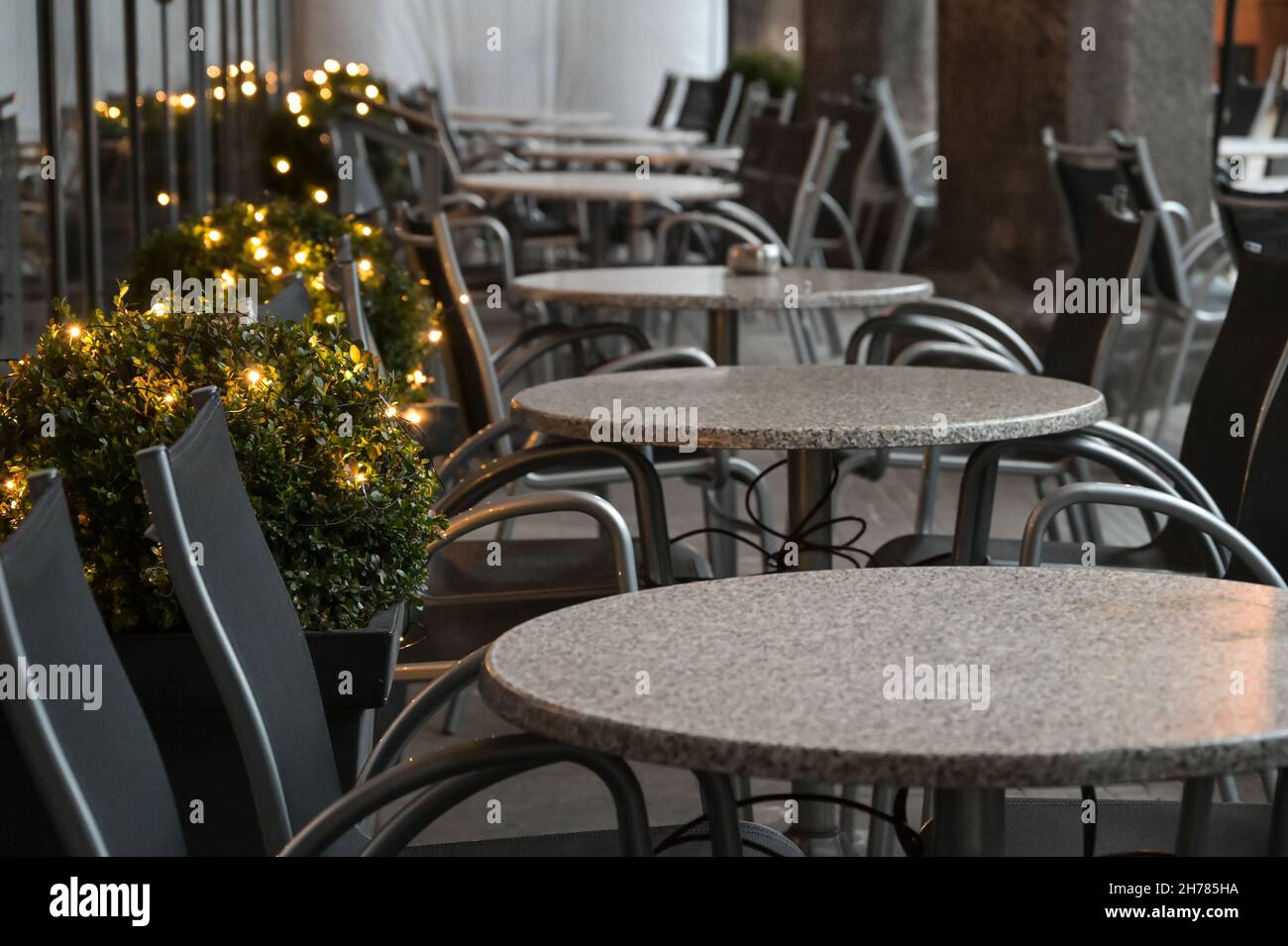 Weihnachtsdekorationen und leere Tische in einem geschlossenen Straßencafé während der wiederholten Sperre in der coovid-19 Pandemie, einer finanziellen Katastrophe, Kopie-spac Stockfoto
