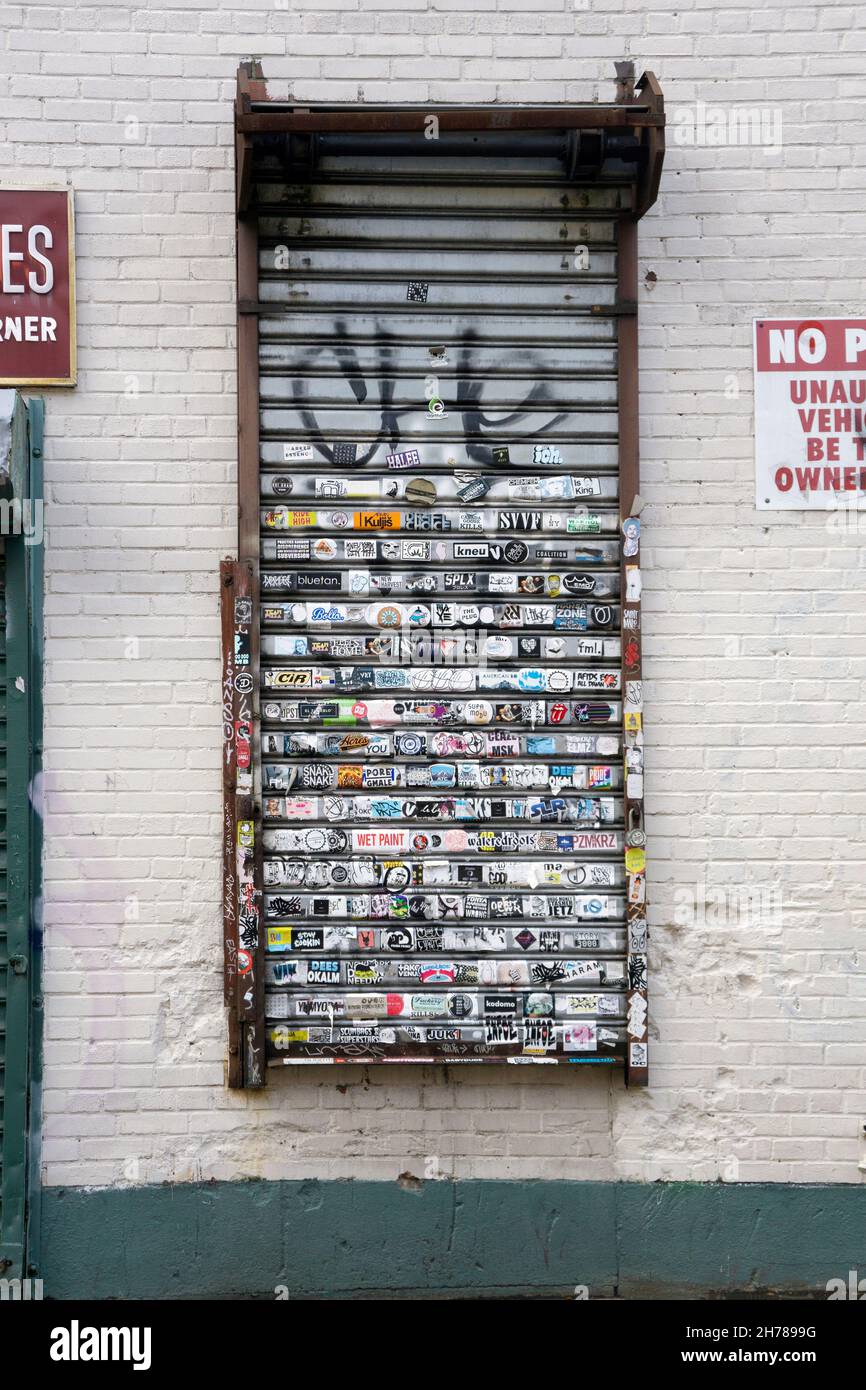 Ein Gitter der Grand Street in Williamsburg mit vielen Aufklebern und einigen Graffiti und Tags. In einem hippen Viertel in Brooklyn, New York City. Stockfoto