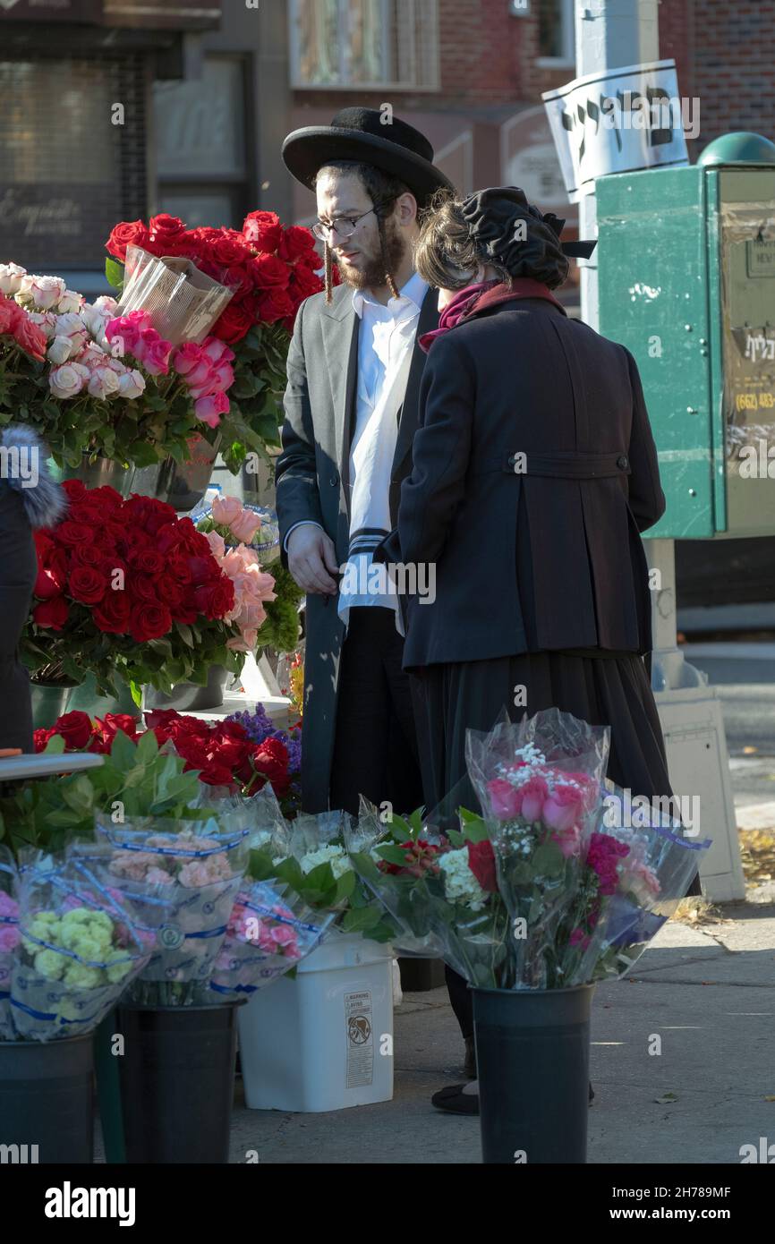 Zur Vorbereitung auf den Sabbat kauft ein orthodoxes jüdisches Paar Blumen. Auf der Lee Avenue in Williamsburg, Brooklyn, New York City. Stockfoto